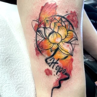 Tatouage d'une fleur jaune et orange watercolor - Black Hat Tattoo Nice - tatouage Nice - The Black Hat Tattoo